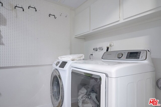 laundry area with cabinets and washer and clothes dryer