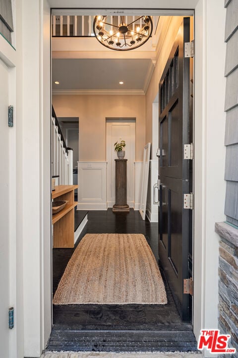 foyer featuring ornamental molding and dark hardwood / wood-style floors