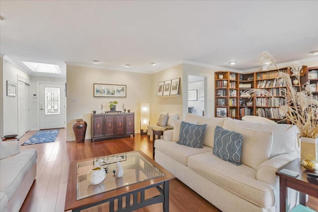 living room with crown molding, a skylight, and hardwood / wood-style floors