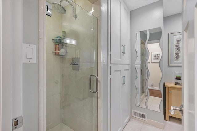 bathroom with tile patterned floors and a shower with door