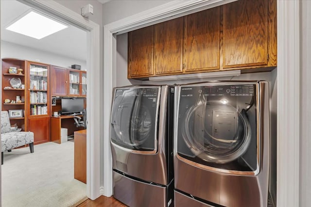 washroom with light colored carpet, washing machine and dryer, and cabinets