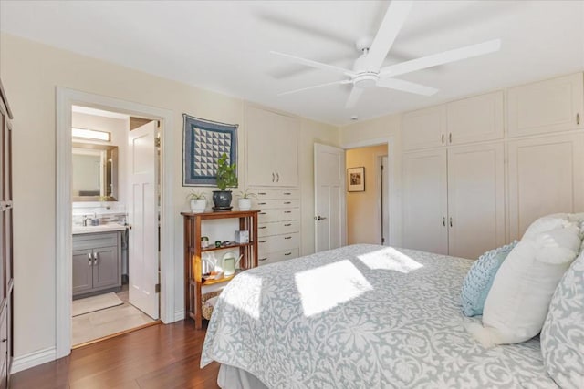 bedroom with ceiling fan, connected bathroom, dark hardwood / wood-style flooring, and a closet