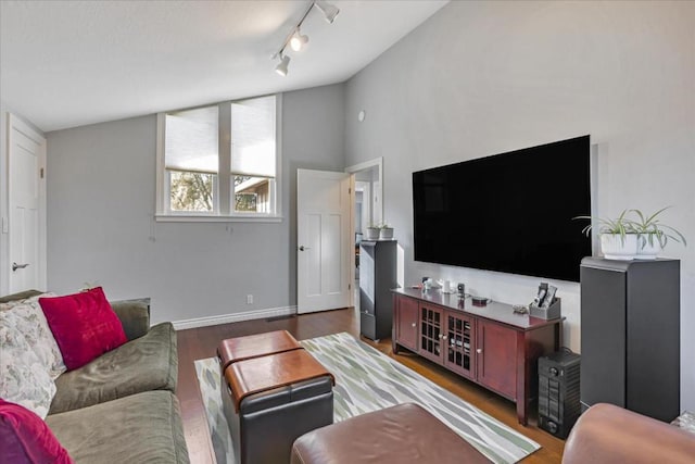 living room with rail lighting, vaulted ceiling, and dark hardwood / wood-style floors