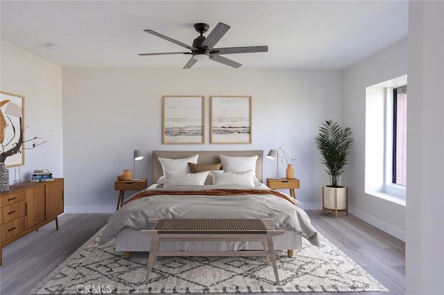 bedroom with wood finished floors, a ceiling fan, and baseboards