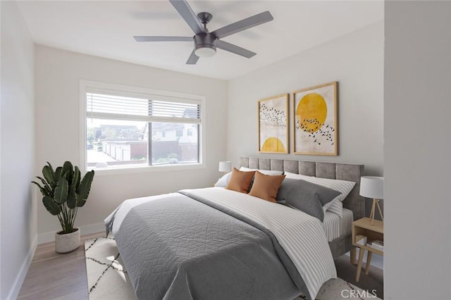 bedroom with light wood-style floors, ceiling fan, and baseboards