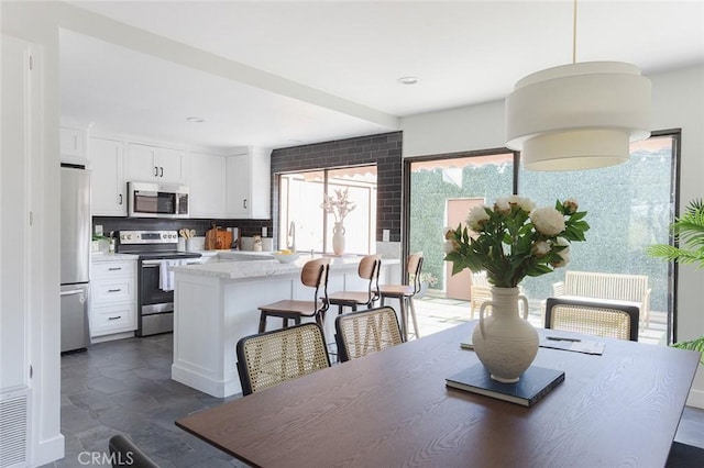 dining space featuring recessed lighting and stone finish flooring