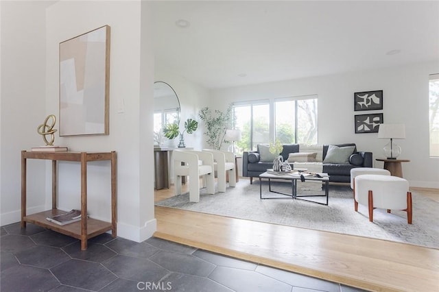 living room featuring dark tile patterned floors, plenty of natural light, and baseboards