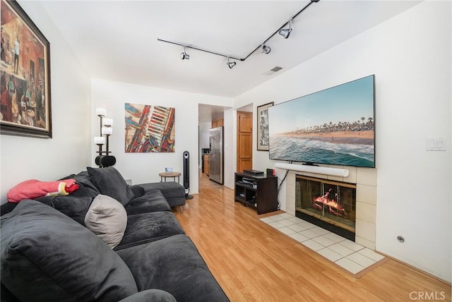 living room with a fireplace and light wood-type flooring