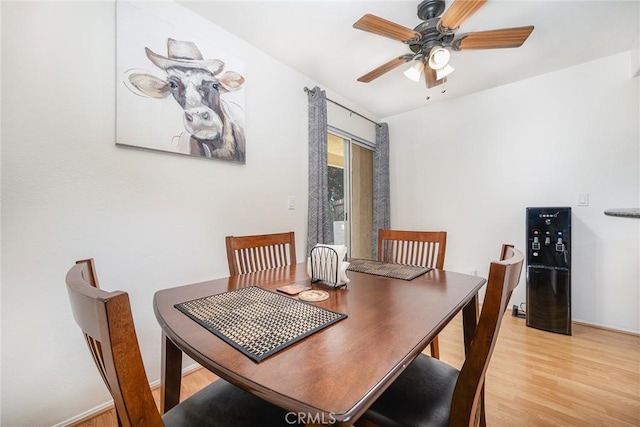 dining space with ceiling fan and light hardwood / wood-style flooring