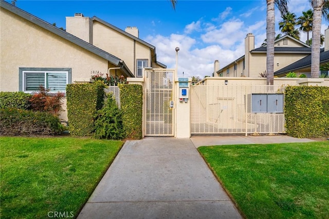 view of gate with a yard