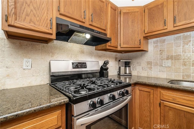 kitchen featuring dark stone counters, gas stove, and decorative backsplash