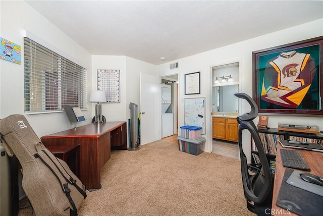 carpeted home office featuring stacked washing maching and dryer