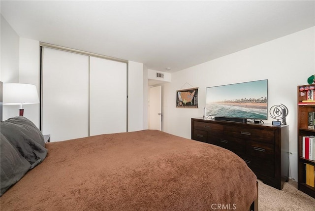 bedroom featuring light carpet and a closet