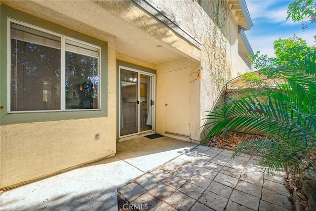 view of exterior entry featuring a patio area