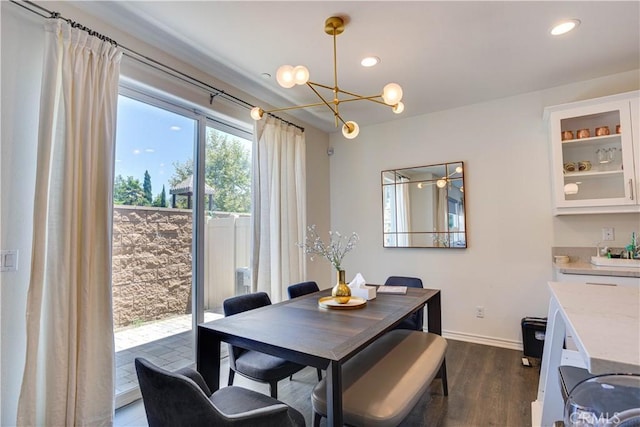 dining area with dark hardwood / wood-style floors and a notable chandelier