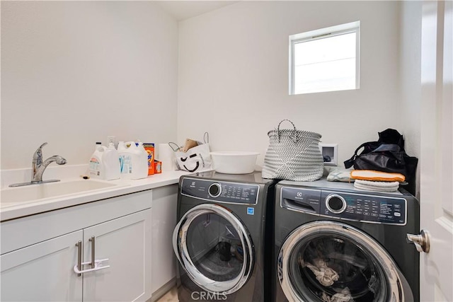 clothes washing area featuring cabinets, separate washer and dryer, and sink