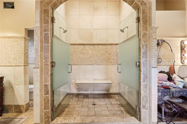 bathroom featuring vanity, tile walls, an enclosed shower, and toilet