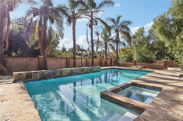 view of pool with an in ground hot tub and a patio