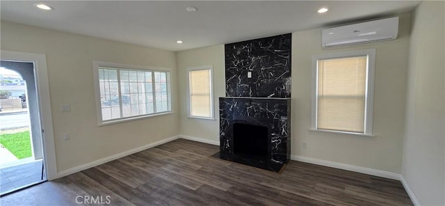 unfurnished living room featuring a wall mounted air conditioner, dark hardwood / wood-style flooring, and a high end fireplace