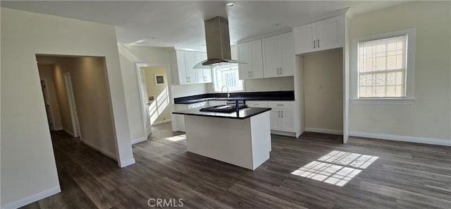 kitchen featuring white cabinetry, a center island, black gas cooktop, island range hood, and dark hardwood / wood-style flooring