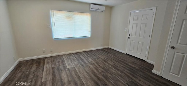 spare room with dark wood-type flooring and a wall unit AC