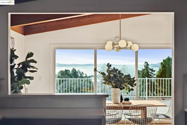 dining area featuring vaulted ceiling, a mountain view, and a notable chandelier