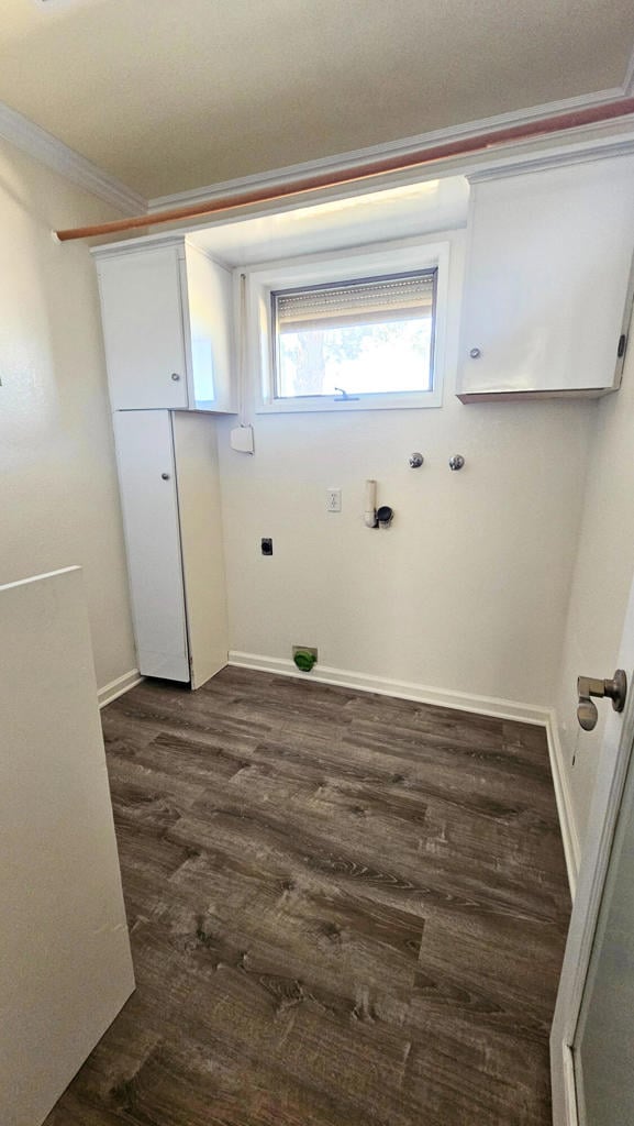 laundry room with crown molding and dark wood-type flooring