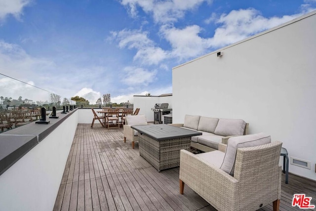 wooden terrace with an outdoor living space