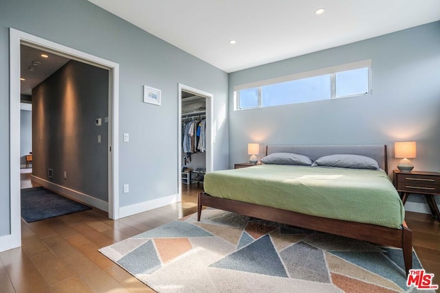 bedroom featuring hardwood / wood-style flooring, a spacious closet, and a closet