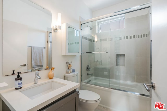 full bathroom featuring vanity, toilet, and combined bath / shower with glass door