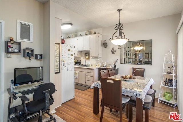 dining space featuring hardwood / wood-style floors and a textured ceiling