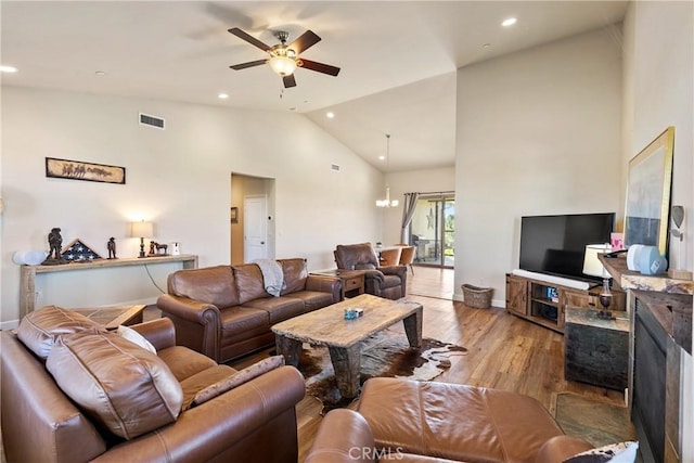 living room featuring ceiling fan, high vaulted ceiling, and light hardwood / wood-style flooring