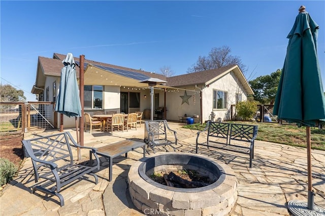 rear view of house featuring a fire pit and a patio