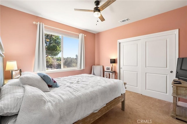 bedroom with light carpet, ceiling fan, and a closet