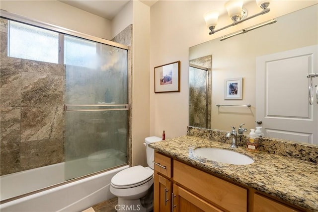 full bathroom with vanity, combined bath / shower with glass door, and toilet