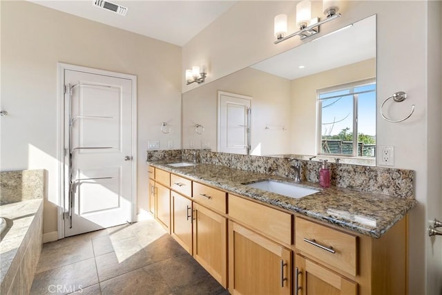 bathroom with vanity and tiled tub