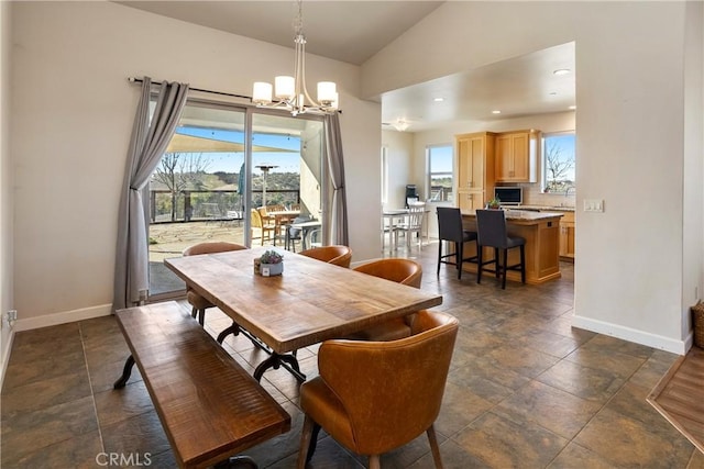 dining space featuring a chandelier and vaulted ceiling