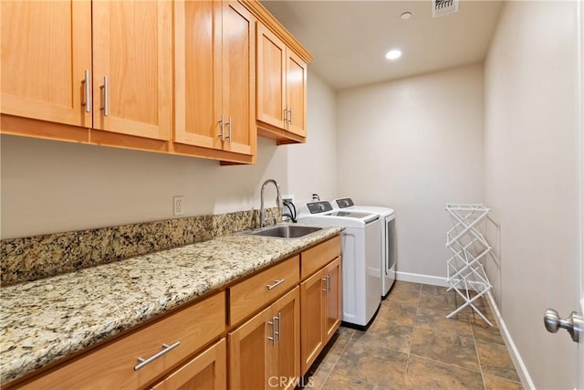 laundry room featuring cabinets, sink, and washing machine and clothes dryer