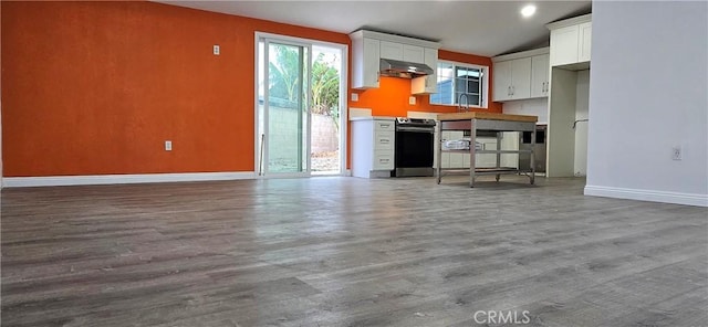 kitchen featuring wood-type flooring, sink, white cabinets, and electric stove