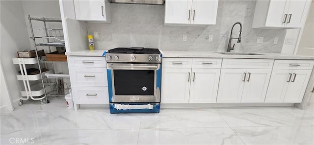 kitchen with tasteful backsplash, sink, white cabinets, and stainless steel gas stove