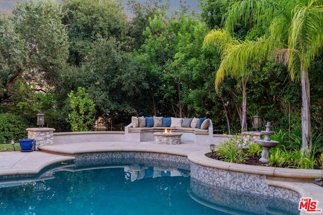 view of pool featuring a patio and a fire pit