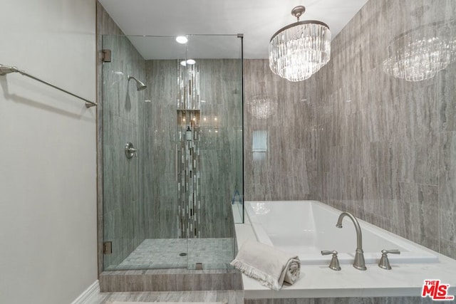 bathroom with a chandelier and separate shower and tub