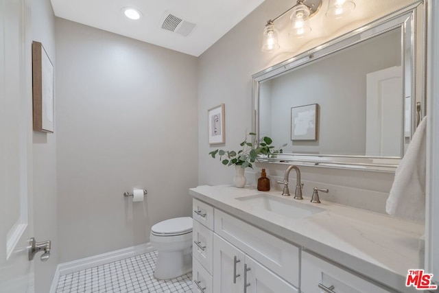 bathroom featuring tile patterned flooring, vanity, and toilet