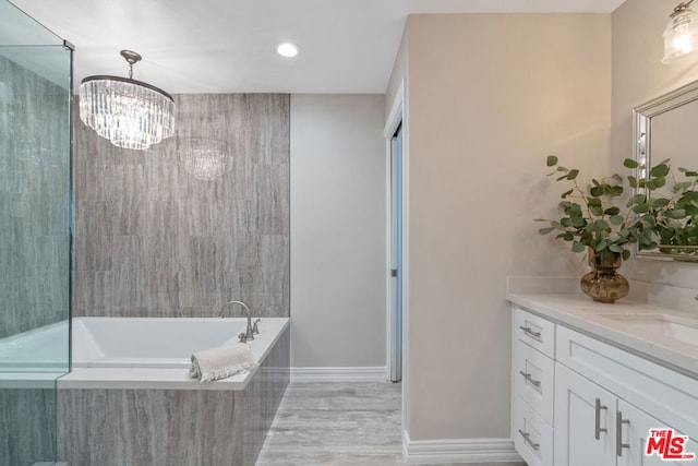 bathroom with vanity and tiled bath