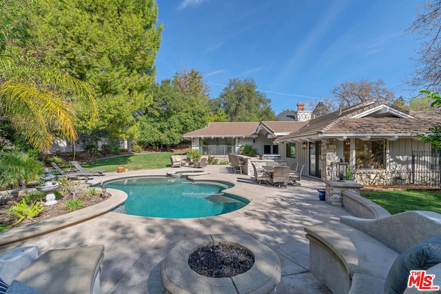 view of swimming pool with a fire pit and a patio