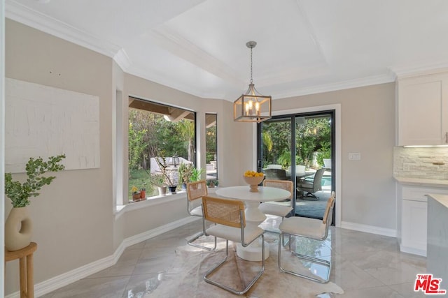 dining area with crown molding, a raised ceiling, and a chandelier