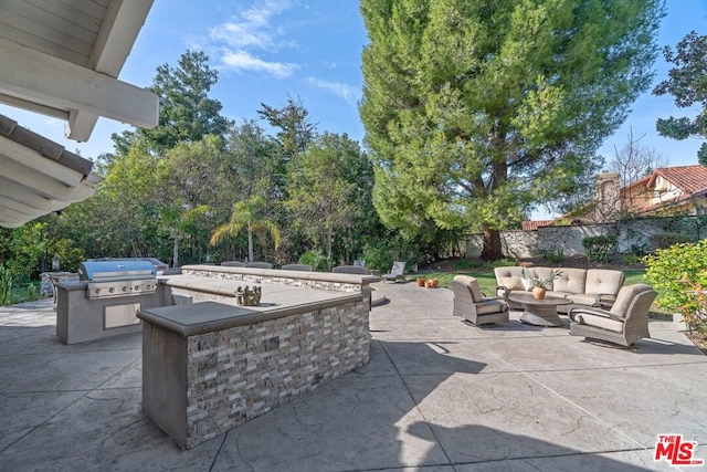 view of patio / terrace featuring an outdoor living space, grilling area, and an outdoor kitchen