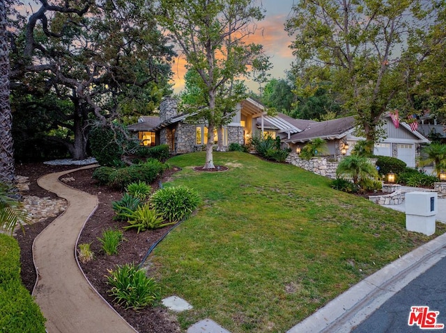 view of front of home with a yard and a garage