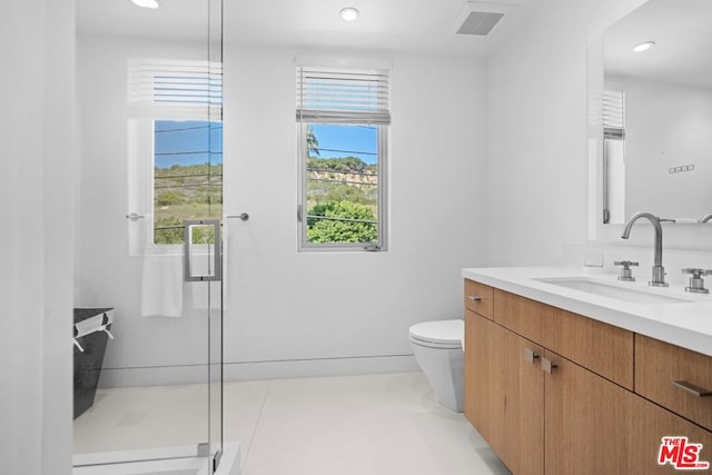 bathroom with an enclosed shower, vanity, tile patterned floors, and toilet