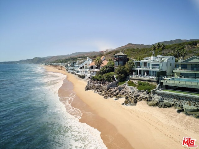 aerial view featuring a water and mountain view and a view of the beach